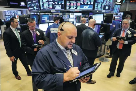  ?? DREW ANGERER/GETTY IMAGES ?? Traders work the floor of the New York Stock Exchange (NYSE) this week. U.S. President Donald Trump has urged regulators to consider reducing how often public companies must report earnings to investors from every three months to every six.