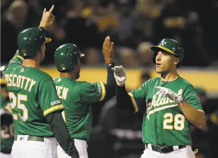  ?? Ben Margot / Associated Press ?? A’s Matt Olson (right) celebrates with Stephen Piscotty and Marcus Semien after hitting a three-run home run in the fourth.