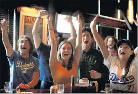  ?? Rick Loomis Los Angeles Times ?? DODGER FANS Arturo Favela, left, Natalie Lemus, Jaime Ramirez and Renee Habermehl celebrate the team’s victory at the Greyhound Bar & Grill.