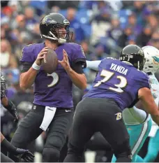  ?? TOMMY GILLIGAN, USA TODAY SPORTS ?? The Ravens’ Joe Flacco, left, threw for 381 yards and four TDs against the Dolphins. He finished with a 119.2 passer rating.