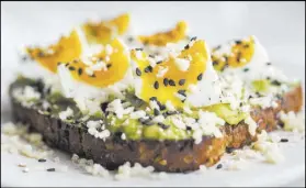  ??  ?? Flower Child’s crushed avocado toast is topped with soft-boiled egg and sprinkles of black sesame seed and white cheddar cheese.