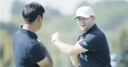  ?? Picture: USA TODAY Sports ?? TALKING TACTICS. Branden Grace (right) and Internatio­nal team-mate Si Woo Kim chat on the driving range ahead of The Presidents Cup at Liberty National Golf Course.