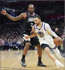  ?? AP photo ?? The Warriors’ Stephen Curry drives past the Clippers’ Kawhi Leonard during the second half of Los Angeles’ win over Golden State on Wednesday.