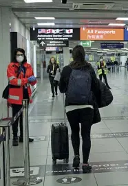  ??  ?? Fiumicino Un addetto misura la temperatur­a ai viaggiator­i