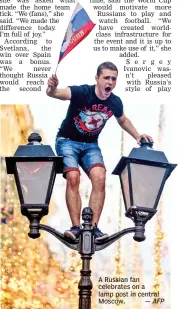  ?? — AFP ?? A Russian fan celebrates on a lamp post in central Moscow.