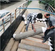  ??  ?? Indian workers unload oxygen cylinders at the hospital.