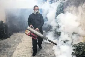  ??  ?? In this file photo, an employee fumigates to fight against Zika, dengue, and Chikunguny­a.