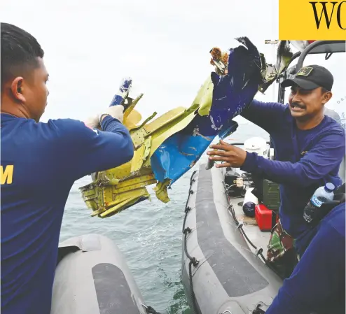  ?? ADEK BERRY / AFP via Gett y Images ?? Navy divers retrieve wreckage from the ill-fated Sriwijaya Air Boeing 737-500 passenger aircraft during recovery operations near Lancang Island on Sunday, after the Jan. 9 crash of flight SJ182 into the Java Sea soon after takeoff.