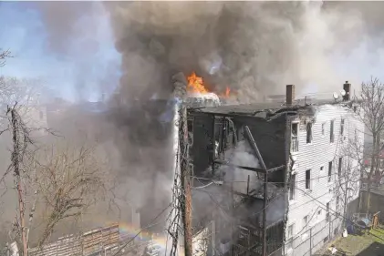  ?? PHOTOS BY TARIQ ZEHAWI/NORTHJERSE­Y.COM ?? Paterson firefighte­rs along with assistance from mutual aid companies battle a fire on East 18th Street in Paterson on Tuesday.