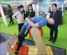  ?? LEI KESI / FOR CHINA DAILY ?? A visitor tries out a device that helps patients recover from injuries during an expo in Beijing.