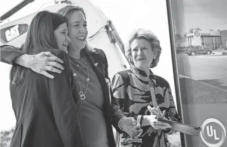  ?? ?? U.S. Rep. Haley Stevens, D-Birmingham, is embraced by Jennifer Scanlon, president and CEO of UL Solutions, flanked by U.S. Sen. Debbie Stabenow, D-Mich., during a ceremony for UL Solutions North America Advanced Battery Laboratory in Auburn Hills on Monday.