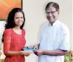  ??  ?? Chathushki­e presenting the book to her grandfathe­r Thalangama Jayasinghe