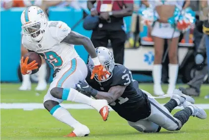  ?? MARC SEROTA/GETTY IMAGES ?? Dolphins WR Jakeem Grant (19) turns a shovel pass into an 18-yard TD reception late in the 3rd quarter that helped spark Sunday’s victory.