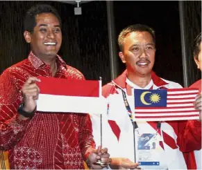  ?? — AP ?? Friendly neighbours: Khairy (left) and Imam holding the national flags of Malaysia and Indonesia after Khairy apologised to Indonesia for the mistake.