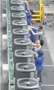  ??  ?? Workers assemble airconditi­oning units in the new facility. Daikin began its move here in 2012 when it bought Houstonbas­ed Goodman Global Inc., making it the largest airconditi­oner manufactur­er in the world.