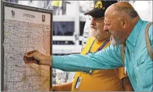  ??  ?? CLIFF d’AUTREMONT has fellow Iowan William Weldon mark his hometown on a map at the Iowa Picnic, a 119-year-old tradition.