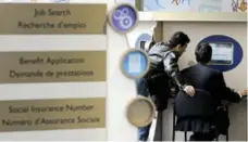  ??  ?? Two men check job postings at a Service Canada centre in Toronto.