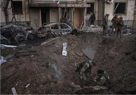  ?? ?? EXPLOSION: A Ukrainian bomb squad inspects the site of an explosion after bombing in Kyiv, Ukraine, Sunday.