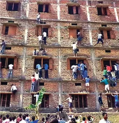  ?? AFP/GETTY IMAGES PHOTOS ?? Formal tests in India are frequently fraught, high-pressure affairs. Here, relatives of students taking school exams climb the walls of the exam building to pass in test answers.