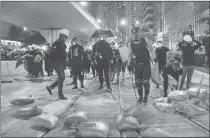  ?? Zuma Press/tns ?? Protesters attempt to use sand bags to block the road to slow down the police’s advance towards them on July 21 in Hong Kong.