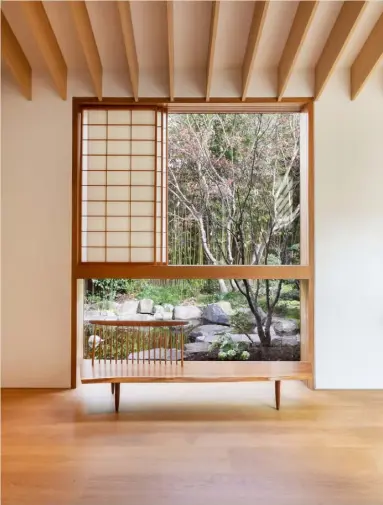  ??  ?? Above A shoji screen opens up to reveal the Japanese garden. This wooden ‘Conoid’ bench by George Nakashima is the perfect place to take in the view Opposite, top Located in one of the sections of the
house untouched by Kengo Kuma & Associates, this room features the same oak floors, as well as a selection of iconic designer chairs – the ‘F572’ by Pierre Paulin for Artifort, ‘Wicker Chair’ by Marc Newson for Idée and a sculptural wooden chair by Korean artist Jae Hyo Lee. The floor lamp behind
is by Serge Mouille Opposite, bottom Located just off the tatami-floored tea room, the low-cushioned engawa, or covered porch, provides a corner for contemplat­ion, connecting
the home to the calm courtyard beyond