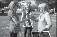  ?? NWA Democrat-Gazette/CHARLIE KAIJO ?? Susan Inman (right), a candidate for Secretary of State, with Nancy Eddy of Little Rock, gives a business card to Liz Lottmann, secretary of the Democratic party in Bella Vista, Saturday during a fundraisin­g picnic at the city park in Little Flock.