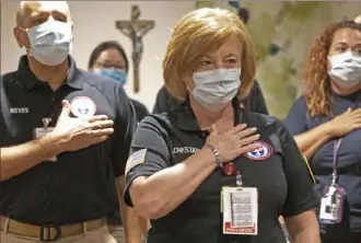  ?? Ted Jackson/Associated Press ?? Lisa Chestang, a paramedic from Mobile, Ala., recites the Pledge of Allegiance with nearly three dozen health care workers who arrived to help supplement the staff at Our Lady of the Lake Regional Medical Center in Baton Rouge, La., on Monday.