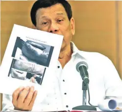  ??  ?? CRUEL ACTS – President Rodrigo Roa Duterte shows photos of Filipina workers reportedly maltreated by their employers in Kuwait in a press conference in Davao City Friday night. Because of these persistent reports of maltreatme­nt and even death of...
