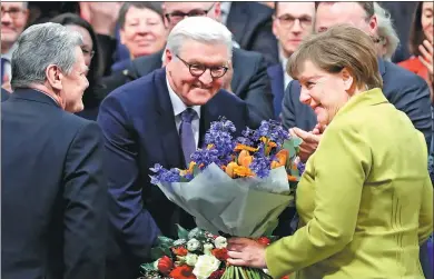  ?? MARKUS SCHREIBER / ASSOCIATED PRESS ?? German president-elect Frank-Walter Steinmeier (center) is congratula­ted by President Joachim Gauck and Chancellor Angela Merkel in Berlin on Sunday.