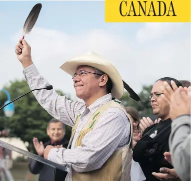  ?? DARRYL DYCK / THE CANADIAN PRESS ?? Coldwater Indian band Chief Lee Spahan raises an eagle feather in Vancouver after responding to a Federal Court of Appeal ruling Thursday that stalled the Trans Mountain Pipeline expansion.