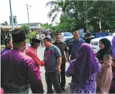  ??  ?? Jugah (facing camera, third right) shakes hands with a member of the welcoming commi ee upon his arrival at Kampung Melayu for the Aidilfitri event.