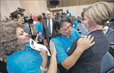  ?? Al Seib Los Angeles Times ?? COMPTON RESIDENT Martha Barajas, center, hugs L.A. County Supervisor Janice Hahn on Wednesday after a county commission voted to dissolve the Sativa water district, which has weathered years of scandals.