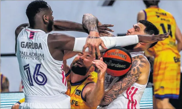  ??  ?? Usman Garuba y Vincent Poirier, que realizó un fabuloso partido, asfixian a Matt Costello en defensa en el primer partido de cuartos del playoff de la Liga Endesa.