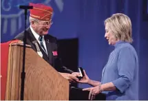  ?? ANDREW HARNIK, AP ?? American Legion National Commander Dale Barnett presents an award to Hillary Clinton after her speech Wednesday at the American Legion’s 98th annual convention in Cincinnati.