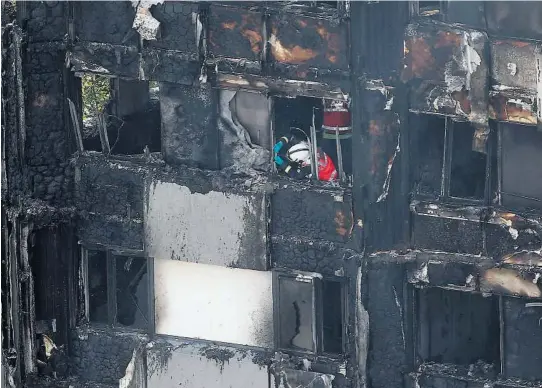  ?? FOTO: REUTERS/NTB SCANPIX ?? KATASTROFE­BRANN: En brannmann undersø ker materiale onsdag i det utbrente hø yhuset i London. Seks mennesker er bekreftet omkommet, men mange er ikke gjort rede for.