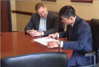  ?? Courtesy photo ?? Valencia High grad Keston Hiura, right, signs with the Milwaukee Brewers as Director of Amateur Scouting Tod Johnson looks on. Hiura was the No. 9 overall pick in last week’s MLB Draft.