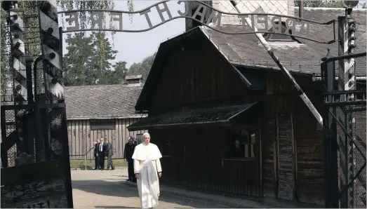  ?? PICTURE: REUTERS ?? Pope Francis walks through a gate bearing the words Arbeit macht frei (Work sets you free) at the former Nazi German concentrat­ion and exterminat­ion camp Auschwitz-Birkenau in Oswiecim, Poland, yesterday.