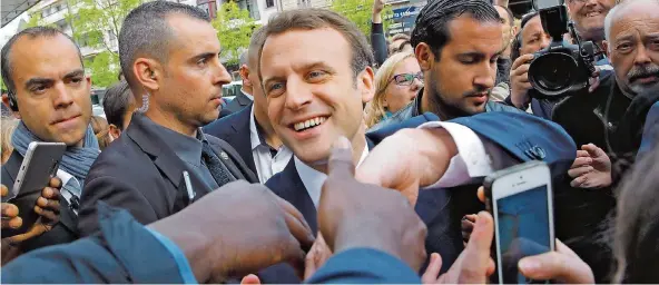  ?? FOTO: DPA ?? Händeschüt­teln beim Bad in der Menge: Emmanuel Macron bekam auch gestern wieder viel Zuspruch. Aber das allein reicht nicht aus für einen Sieg. Auch Marine Le Pen hat ihre Fans.