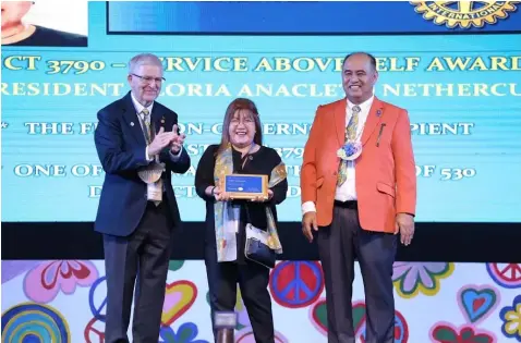  ?? — Photo courtesy of Ron Nethercutt ?? AWARD. Gloria Nethercutt, a member of the Rotary Club of Mabalacat (RCM), receives the Rotary Internatio­nal Service Above Self Award. Presenting the award are Mervyn Ericson, representa­tive of the RI president and District 3790 Governor Boboy Valles.