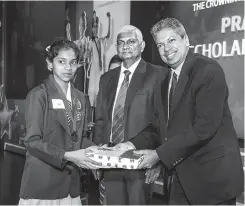  ??  ?? A recipient receives a National Merit Award from Chief Guest Professor Ajantha Dharmasiri (Right) and Ceylinco Life Managing Director R. Renganatha­n (Middle)