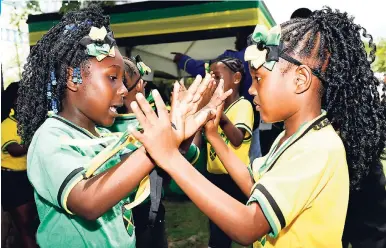  ?? GLADSTONE TAYLOR/PHOTOGRAPH­ER ?? Yallahs Primary School students Latania Lawrence (left) and Kristine Gordon play a game after the formalitie­s were concluded at the official launch of the Houses of Parliament Design Competitio­n held at the National Heroes Circle in Kingston, yesterday.