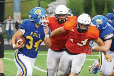  ?? DAVID C. TURBEN — THE NEWS-HERALD ?? NDCL running back Zach Urda (24) carries while North’s Sean Turschon (73) pursues on Aug. 16.