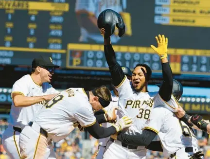  ?? JUSTIN K. ALLER/GETTY PHOTOS ?? Edward Olivares celebrates with teammates after his RBI groundout lifted the Pirates to a 3-2 walk-off win over the Orioles on Sunday in Pittsburgh.