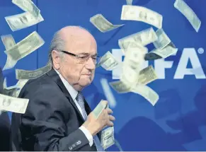  ?? FOTO: DPA ?? Auf einer Pressekonf­erenz wird der derzeit gesperrte Fifa-Präsident Joseph Blatter von einem Comedian mit Banknoten beworfen.Gegen Blatter gab es Vorwürfe der Veruntreuu­ng.