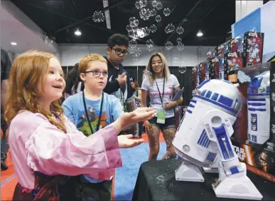  ?? MARK RALSTON / AGENCE FRANCE-PRESSE ?? Young visitors play with a bubble-making R2-D2 robot at a California, on Saturday. store during the D23 expo at the Convention Center in Anaheim,