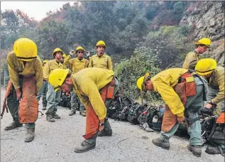  ?? A U.S. FOREST SERVICE Irfan Khan Los Angeles Times ?? fire crew gets ready to create a fire line during the Bobcat fire above Arcadia. The fire damaged many of the rugged trails ultra runner Jerry Garcia uses.