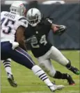  ?? EDUARDO VERDUGO, THE ASSOCIATED PRESS ?? Oakland Raiders running back Marshawn Lynch (24) rushes against New England Patriots linebacker David Harris on Sunday. U.S. President Donald Trump tweeted Lynch should be suspended for his anthem antics.