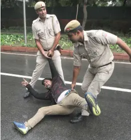  ?? — BIPLAB BANERJEE ?? Policemen detain a Congress supporter in New Delhi on Saturday during a protest over the Rafael deal.