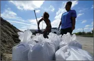  ?? (AP/Gerald Herbert) ?? Stephanie Verrett and Jodie Jones fill sandbags Wednesday in Houma, La., in anticipati­on of Hurricane Delta, which is expected to arrive along the Gulf Coast later this week.