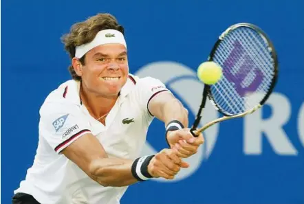  ??  ?? Hitting back: Milos Raonic returns a shot to Viktor Troicki during their Toronto Masters match on Tuesday. Raonic won 6-3, 6-4.